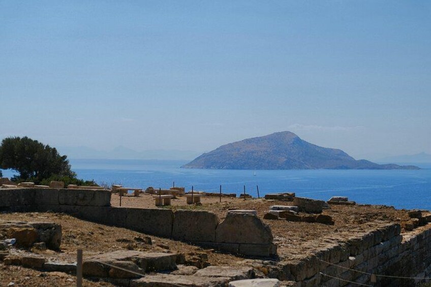 Ancient ruins, a stone wall, and a distant mountain by the sea. 2