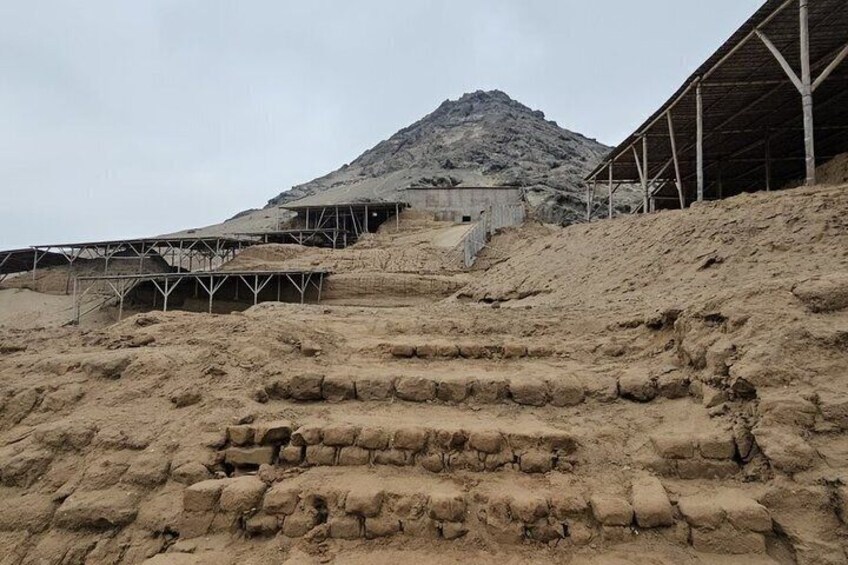 Un paysage désertique avec une grande colline, un chantier de construction avec des structures métalliques et un bâtiment en cours de construction. 2