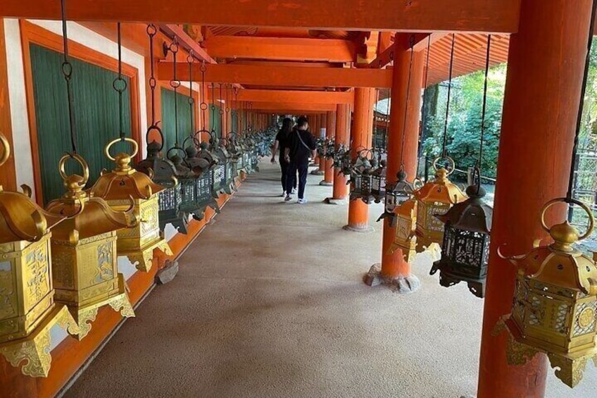 A corridor with ornate lanterns and a person walking. 5