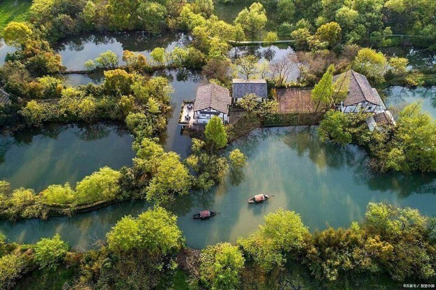 An aerial view of a water body with houses surrounded by lush greenery. 2