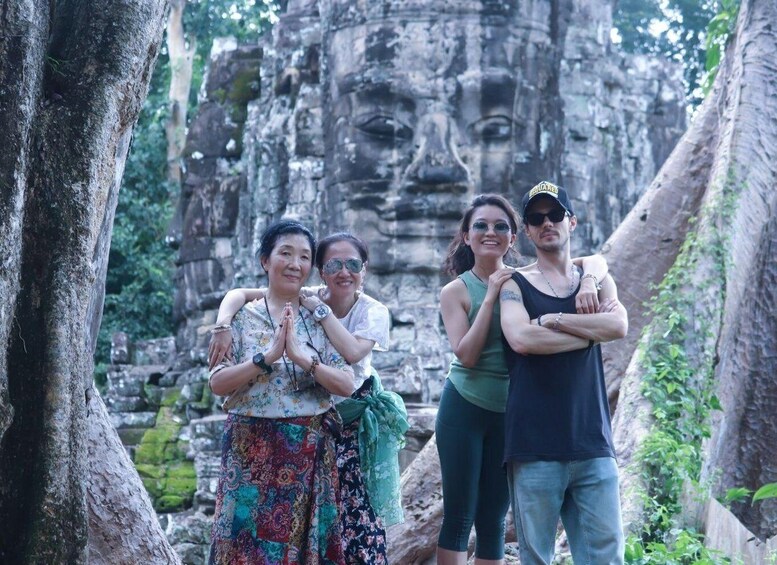 A group of people standing in front of a large stone structure with intricate carvings. 4