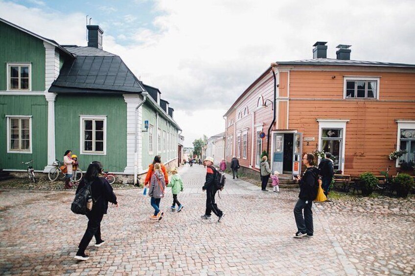 A cobblestone street lined with historic buildings, people walking, and bicycles parked. 2