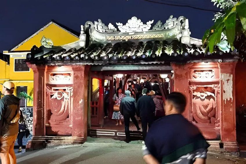 A traditional building with ornate architecture, a tiled roof, and a red entrance. 4