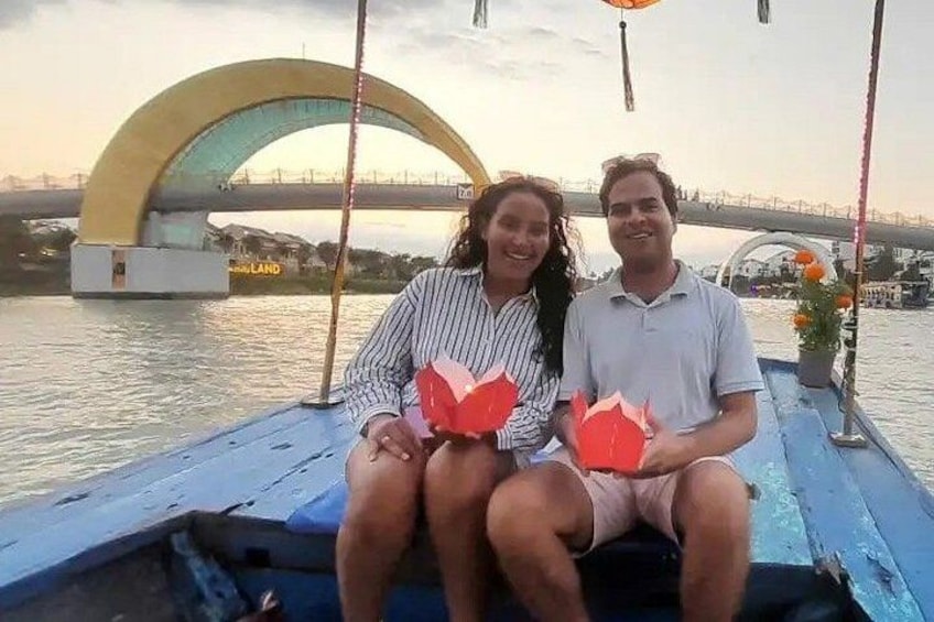 Two people on a boat with a bridge in the background. 2