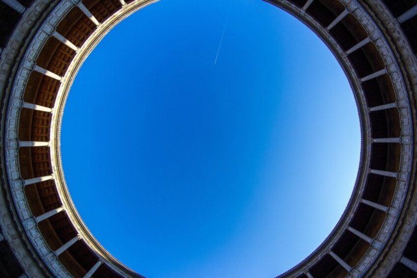 A circular architectural structure with a clear blue sky in the background. 2