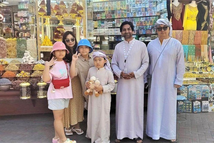 A group of people standing in front of a shop with various items on display. 5