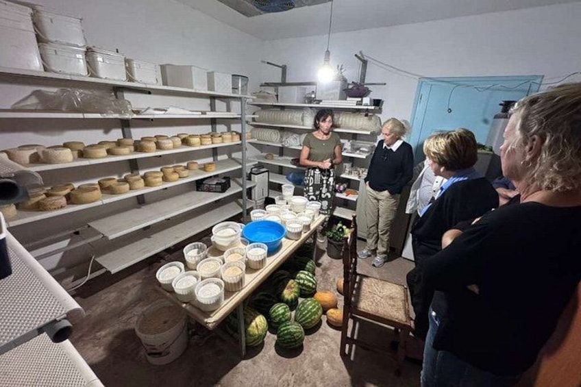 Una cocina con estantes llenos de cuencos y una mesa con frutas. 1