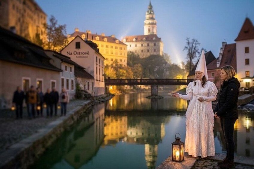 Ein Paar steht an einem Fluss, im Hintergrund eine Burg. 2