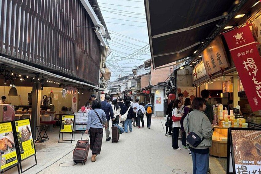 Una calle concurrida, gente caminando, tiendas y letreros en un idioma extranjero. 5