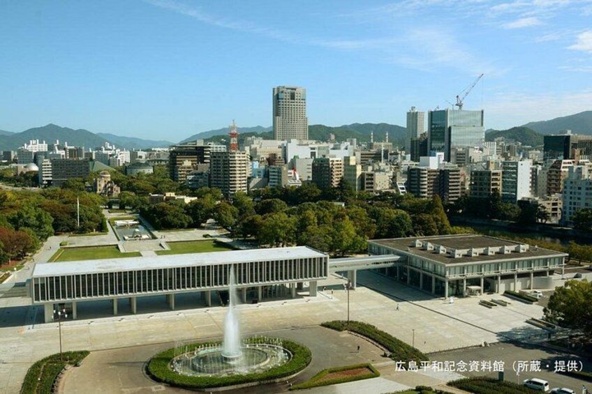 Un paisaje urbano con edificios modernos, una fuente y un parque. 2