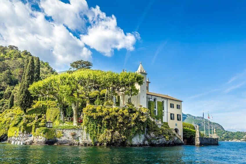 A coastal building surrounded by lush greenery and a clear blue sky. 3