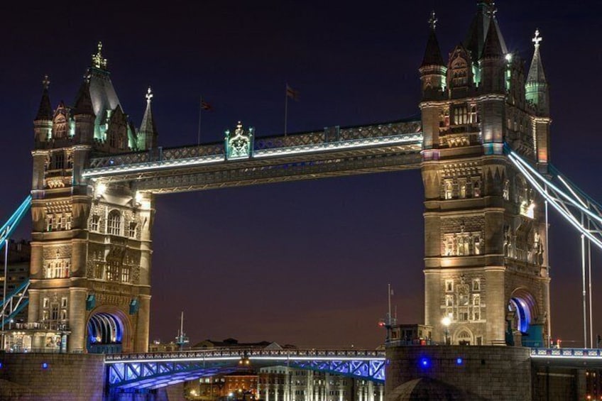 Ein Nachtblick auf die Tower Bridge in London, mit beleuchteten Türmen und der Brückenkonstruktion. 3