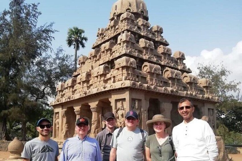 Un groupe de personnes se tient devant un grand temple dont la structure est richement ornée de sculptures complexes. 2