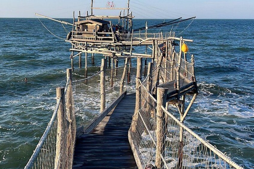 A wooden pier extending into the water with a small boat docked at the end. 5