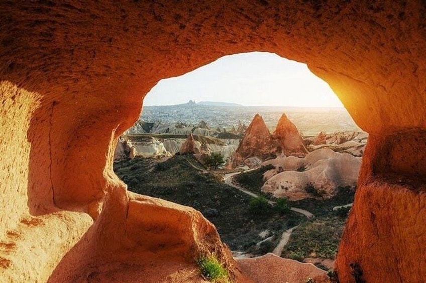 L'entrée d'une grotte, d'où l'on aperçoit un paysage rocheux et, au loin, une ville. 4