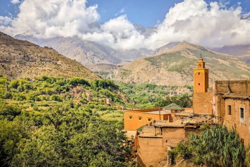 Un pueblo montañoso con campos en terrazas, un minarete destacado y edificios tradicionales. 2