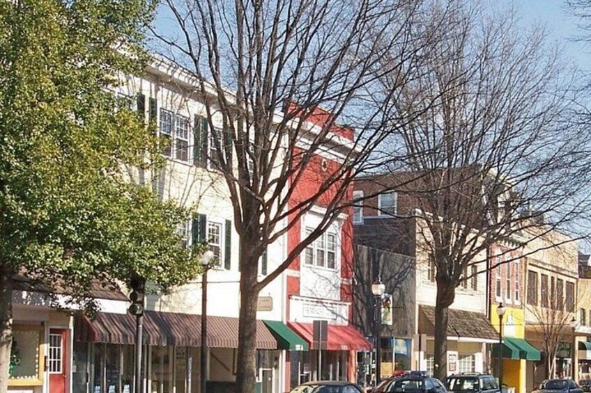 A street with buildings, cars, and trees. 2