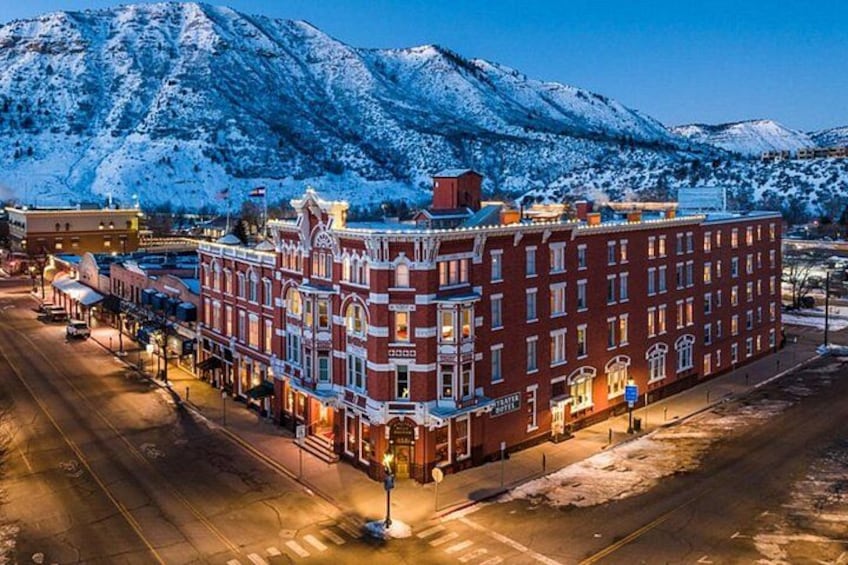 A snow-covered mountain range, a red brick building with ornate detailing, and a street with buildings on either side. 5