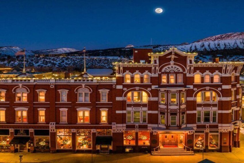 A historic building with a snow-covered mountain in the background. 1