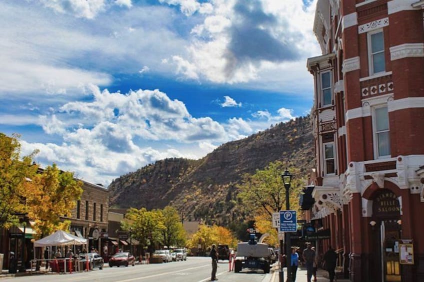 A street with buildings, a mountain, and a clear sky. 4