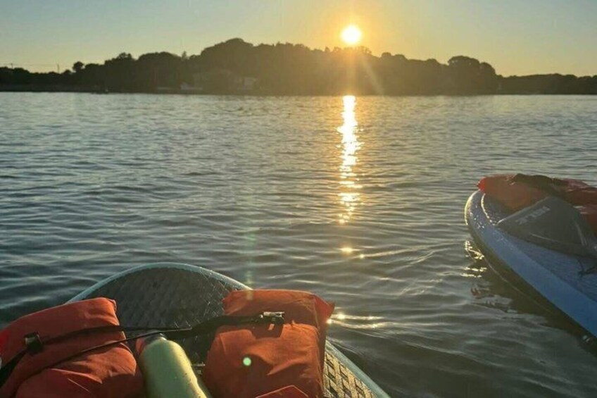 A boat on calm water with a sunset in the background. 3