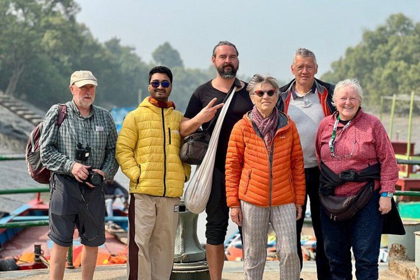 Eine Gruppe von Menschen steht an einem Steg, im Hintergrund sind Boote zu sehen. 2