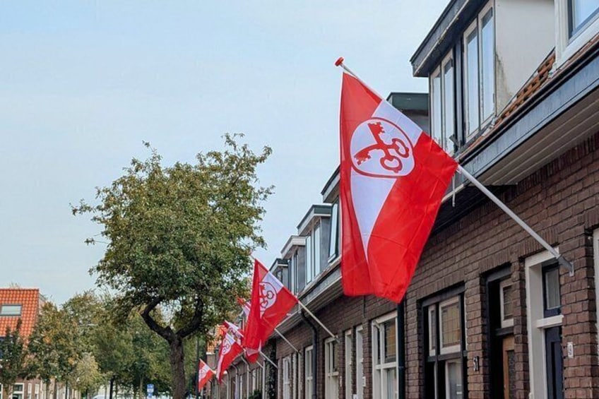 Una hilera de banderas rojas y blancas con un símbolo de llave, colocadas en un edificio. 1