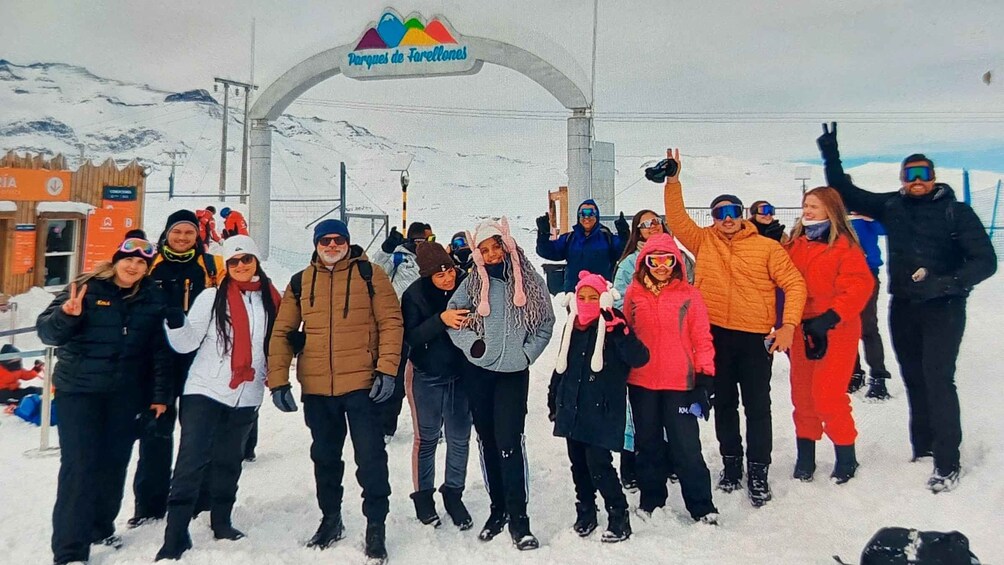 A group of people posing in front of a sign that reads 'Parques de Farellones.' 1