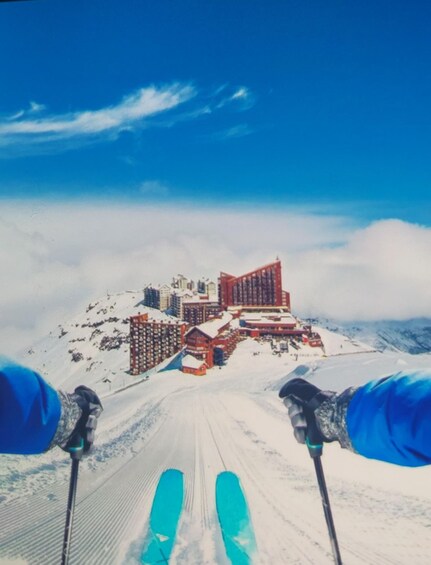 A snowy mountain landscape with a ski resort and buildings in the background. 2