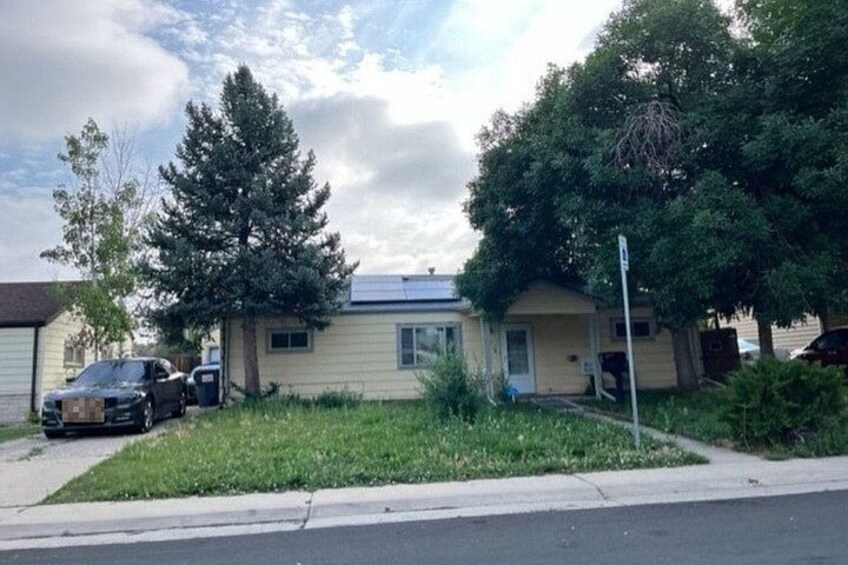 A residential area with houses, a parked car, and a street. 5