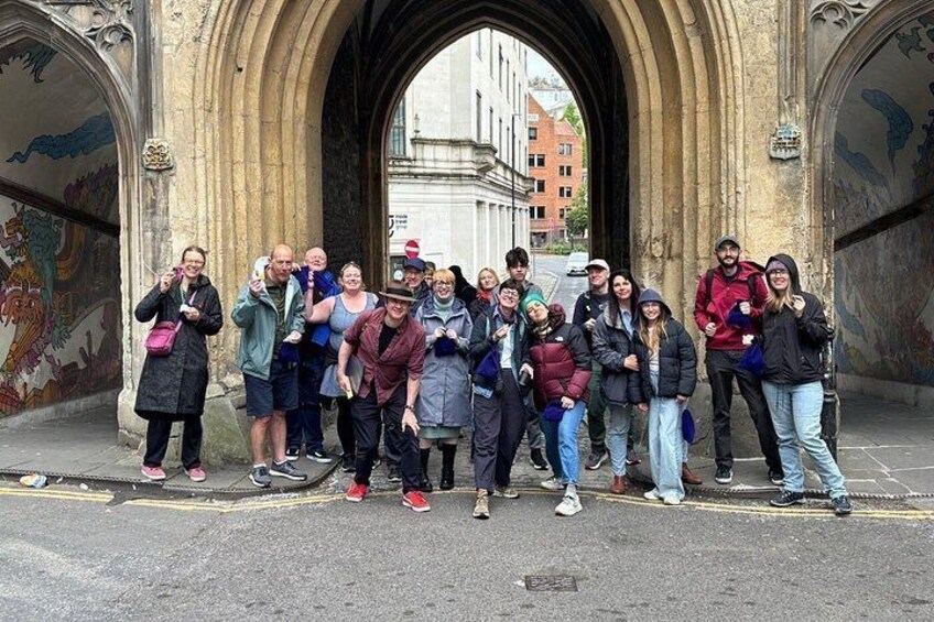 Un groupe de personnes se tient devant une arche dont les murs sont couverts de graffitis. 4