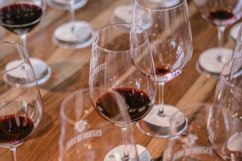 Wine glasses with red liquid on a wooden table. 4