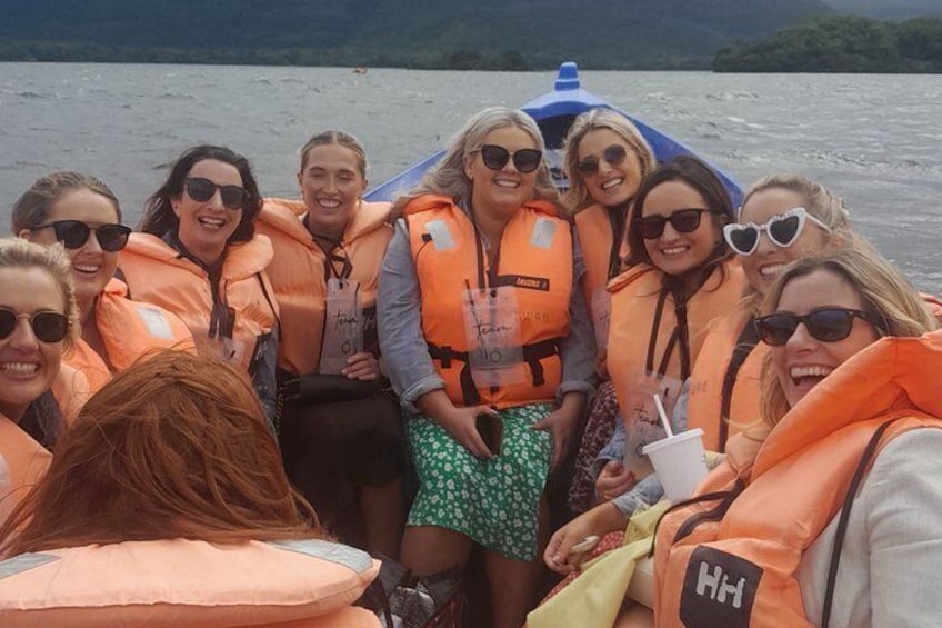 A group of people on a boat wearing life jackets. 5
