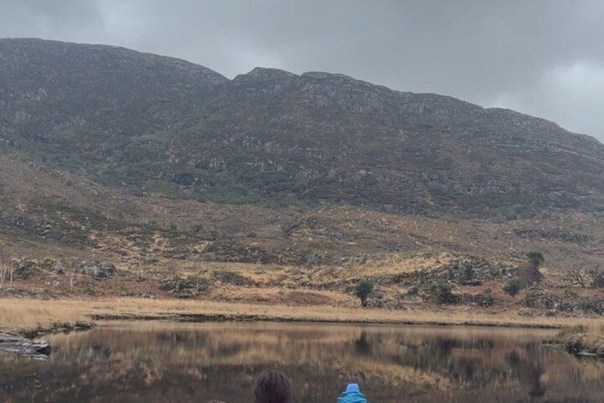 A mountainous landscape with a calm lake reflecting the sky. 2