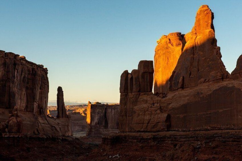 A desert landscape with prominent rock formations and a clear sky. 3