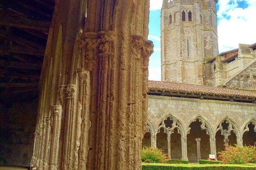 A Gothic-style cathedral with a tall bell tower and a cloister with arches. 4