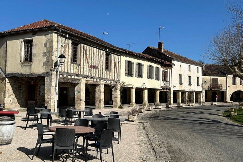 A building with outdoor seating, a street, and a clear sky. 2