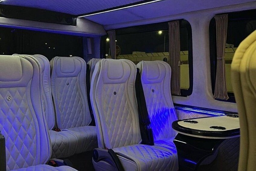 Interior de un tren con asientos tapizados y una mesa. 4