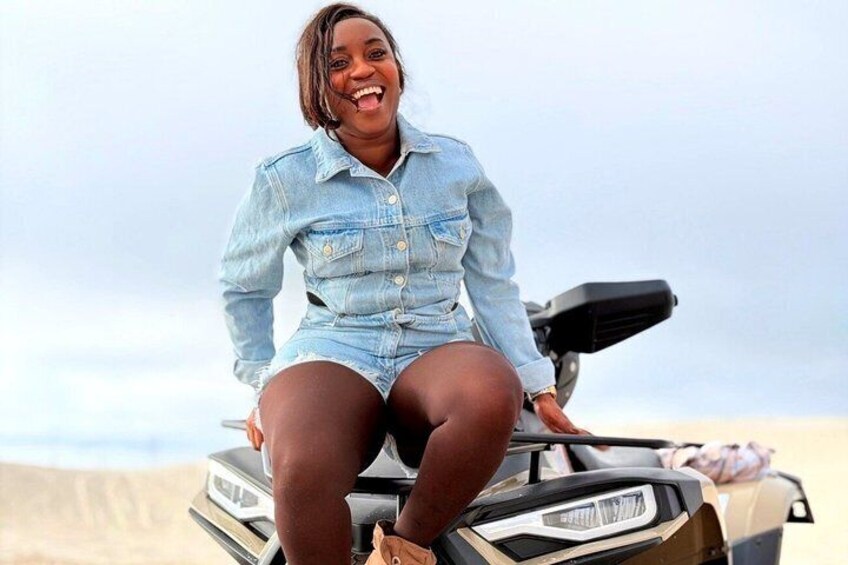A person sitting on a vehicle with a desert landscape in the background. 3
