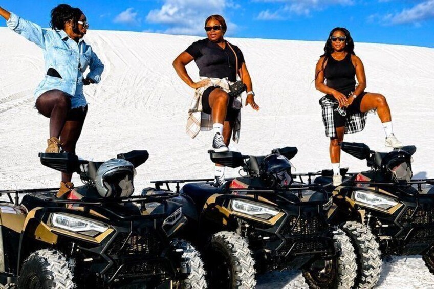 Three people on ATVs in a snowy landscape. 2