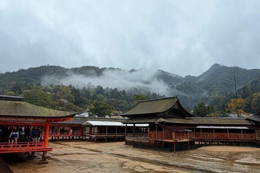 Traditional Japanese buildings with a mountainous backdrop and a cloudy sky. 5