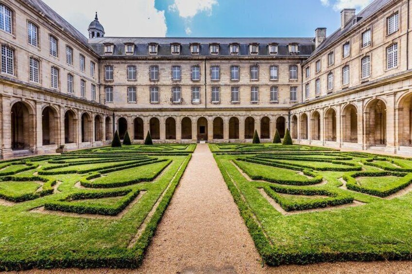 A grand courtyard with symmetrical gardens and classical architecture. 1