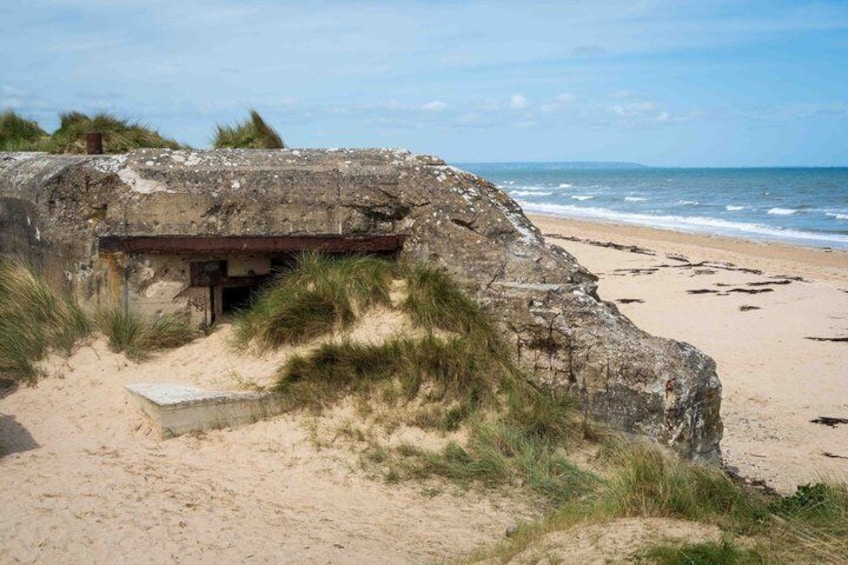 En bunker vid kusten med en sandstrand och havet som bakgrund. 4