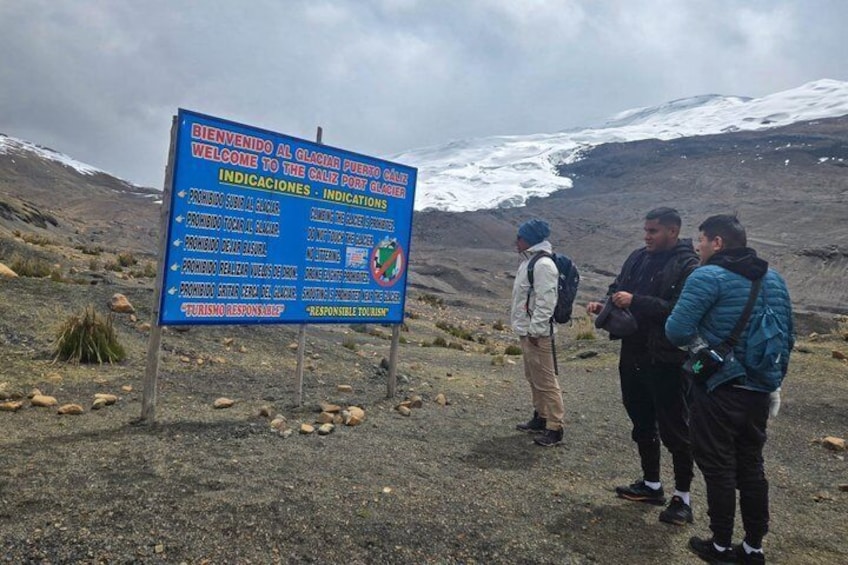 Een groep wandelaars staat bij een bord met instructies voor de Glaciares Port Glacier. 5