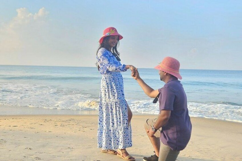 Two people holding hands on a beach with the ocean in the background. 1