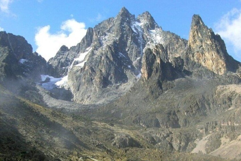 A rugged mountain range with snow-capped peaks and a valley. 4