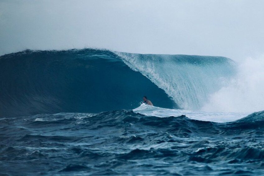 A surfer riding a large wave in the ocean. 4