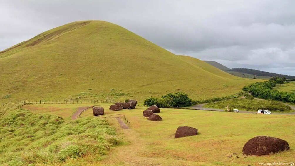 Une colline herbeuse parsemée de gros rochers et traversée d’un sentier sinueux. 3