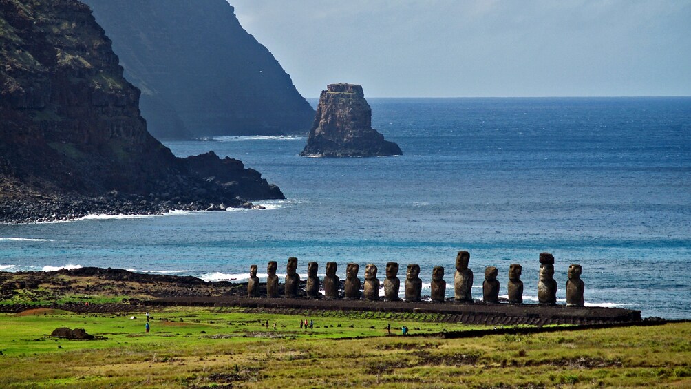 Un paysage côtier caractérisé par une formation rocheuse imposante et une rangée de menhirs. 4