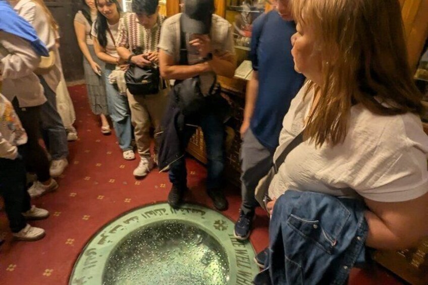 Eine Gruppe von Menschen hat sich um ein grünes, kreisförmiges Objekt versammelt, das mit Text versehen ist, möglicherweise ein Schild oder eine Anzeige. 5